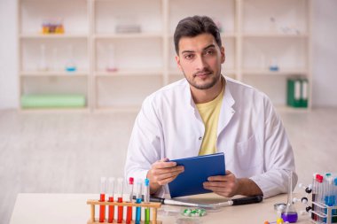 Young chemist sitting at the lab