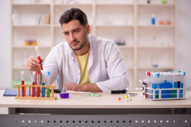 Young chemist sitting at the lab