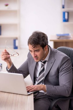 Ofisteki aşırı işten memnun olmayan genç bir çalışan.