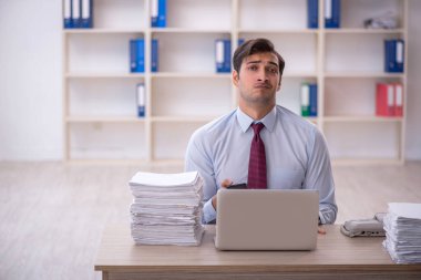 Genç işadamı ve ofiste çok fazla iş var.
