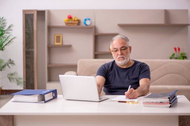 Yaşlı adam salgın sırasında evden çalışıyor.