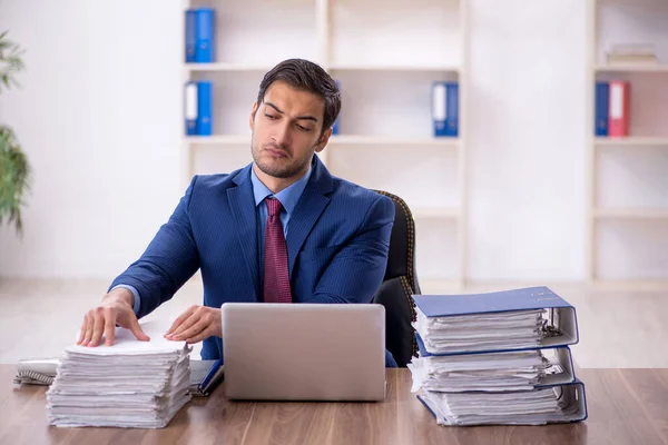 Young businessman employee and too much work at workplace
