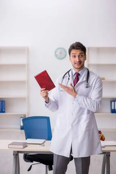 Joven Doctor Leyendo Libro Hospital —  Fotos de Stock