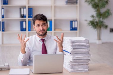 Young employee and too much work at workplace