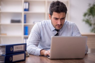 Genç işadamı ve işyerinde çok fazla iş var.