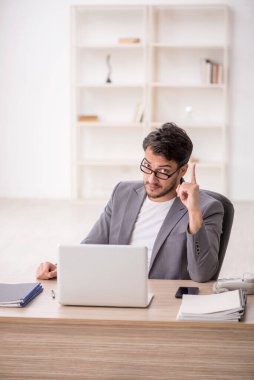 Genç çalışan işyerinde oturuyor.