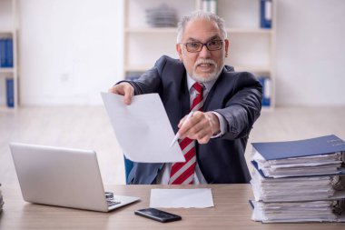 Ofisteki aşırı işten memnun olmayan eski bir işadamı.