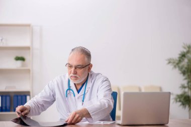 Klinikte çalışan yaşlı bir radyolog.