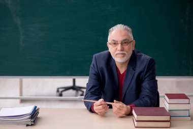 Old teacher sitting in the classroom