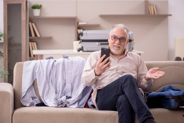 Aged man preparing for trip at home