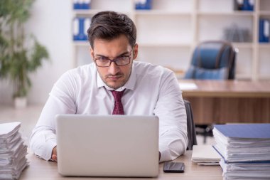 Genç işadamı işyerinde oturuyor.