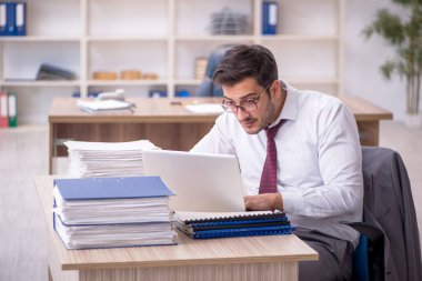 Genç işadamı işyerinde oturuyor.