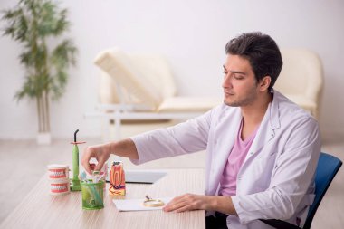 Hastanede çalışan genç bir dişçi.