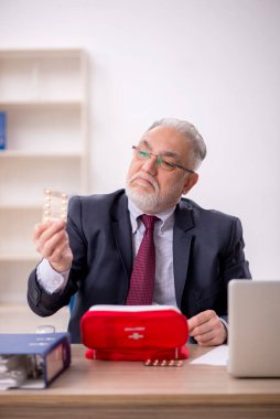 Eski işadamı ofiste kendini kötü hissediyor.