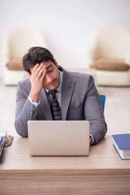 Genç çalışan işyerinde oturuyor.