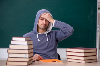 Sınıfta oturan genç öğrenci.