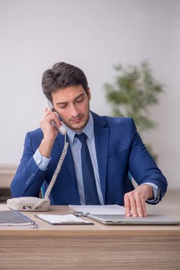 Genç işadamı işyerinde oturuyor.