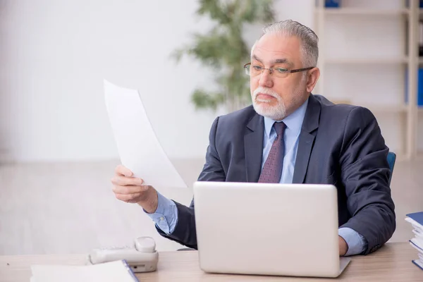 Stock image Old employee working at workplace