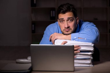 Young employee working late at workplace