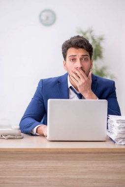 Ofisteki aşırı işten memnun olmayan genç bir çalışan.