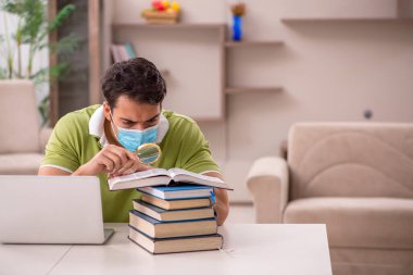 Genç öğrenci salgın sırasında evde sınavlara hazırlanıyor.