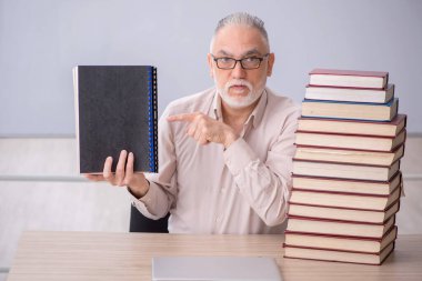 Old teacher sitting in the classroom