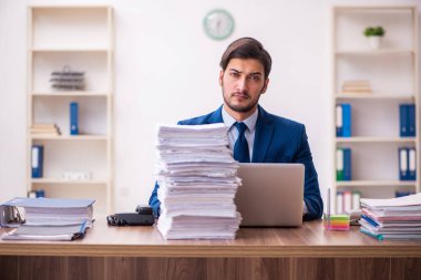 Genç erkek çalışan işyerinde aşırı çalışmaktan memnun değil.