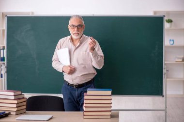 Old teacher sitting in the classroom