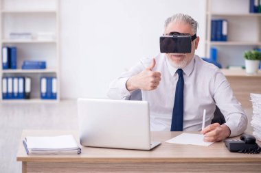 Old businessman employee wearing virtual glasses in the office