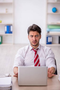 Ofisteki aşırı işten memnun olmayan genç bir çalışan.