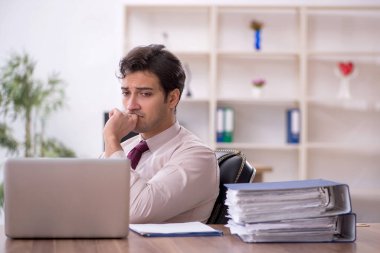 Genç işadamı ve işyerinde çok fazla iş var.