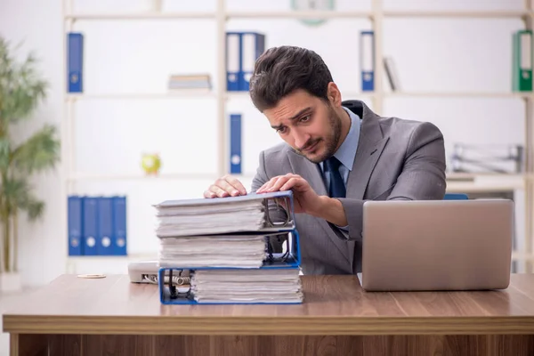 stock image Young employee and too much work at workplace