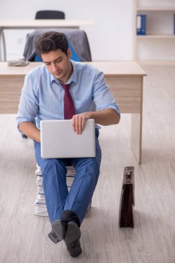 Young employee unhappy with excessive work at workplace