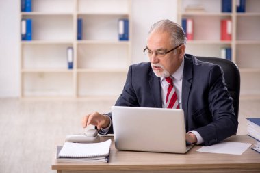 Ofiste çalışan eski bir işadamı.