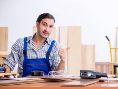 İçeride çalışan genç erkek marangoz.