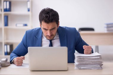 Genç işadamı ve işyerinde çok fazla iş var.