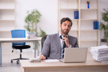 Genç işadamı ve ofiste çok fazla iş var.