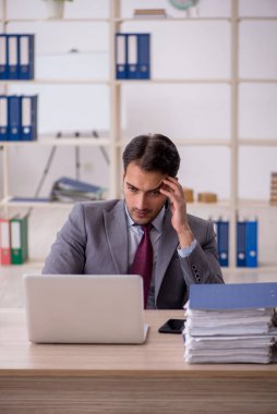 Genç işadamı işyerinde oturuyor.