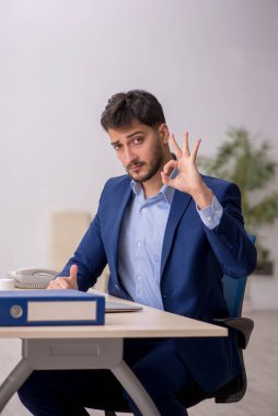 Genç çalışan işyerinde oturuyor.