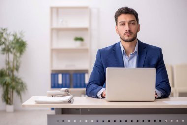 Genç çalışan işyerinde oturuyor.