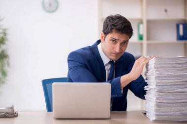 Young employee and too much work at workplace