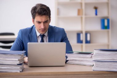 Genç işadamı ve işyerinde çok fazla iş var.