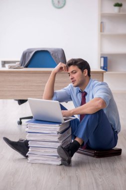 Young employee unhappy with excessive work at workplace