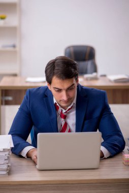 Genç işadamı ve ofiste çok fazla iş var.