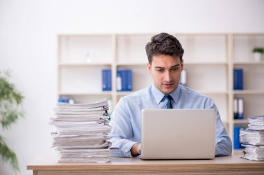 Young employee and too much work at workplace