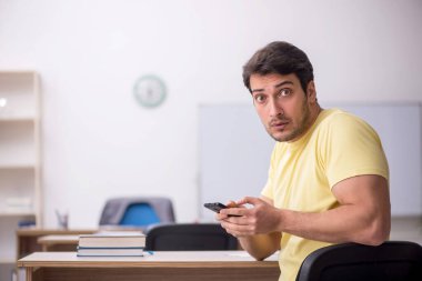 Young student teacher sitting in the classroom