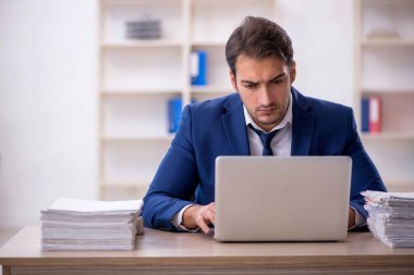 Genç işadamı ve ofiste çok fazla iş var.