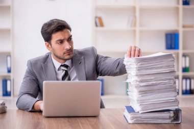 Genç bir çalışan ve ofiste çok fazla iş var.
