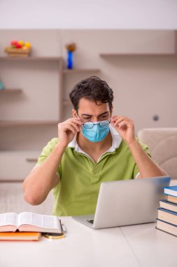 Genç öğrenci salgın sırasında evde sınavlara hazırlanıyor.
