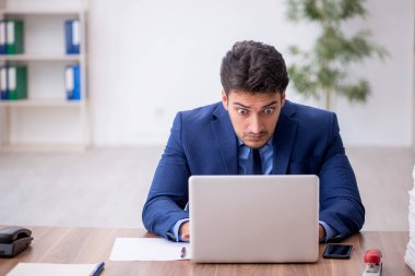 Genç bir çalışan ve ofiste çok fazla iş var.